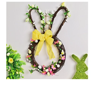 Detail of Easter bunny wreath with speckled eggs and yellow plaid bow on gray wall