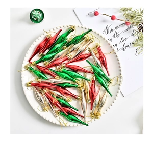 Détail de pendentifs glaçons rouges, verts et argentés avec cordons dorés sur une assiette blanche