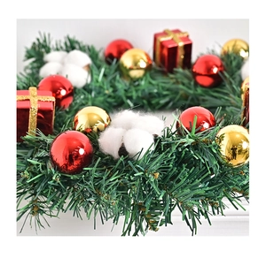 Makrodetail der künstlichen Tannennadeln mit rotem Schmuck und Baumwolle auf Weihnachtskranz