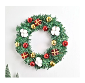 Detailansicht eines Weihnachtskranzes mit Tannennadeln, roten Kugeln und Mini-Geschenkboxen
