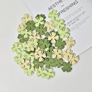 Three-color wooden shamrock cutouts for St. Patrick's Day party decor on white background