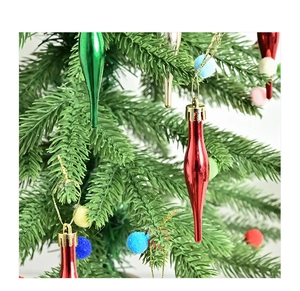Gros plan d'ornements métalliques en forme de goutte et de boules en peluche sur le sapin
