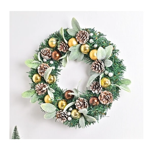 Detail of Christmas wreath with green pine needles, brown pinecones and metallic ornaments