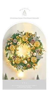 Detail of a Nordic Christmas wreath with pine needles, gold ornaments and warm LED lighting