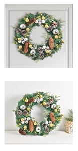 Close-up of a Christmas wreath with pine cones and golden ornaments on a wall
