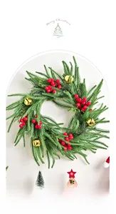 Close-up of Norfolk pine Christmas wreath with red berries and golden bells