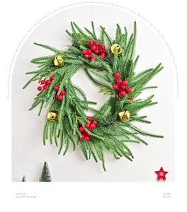 Close-up of artificial Norfolk pine wreath with red berries and golden bells for Christmas