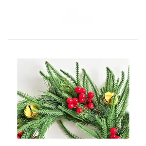 Detail showing green Norfolk fir pine needles, red berries, and golden bells decoration