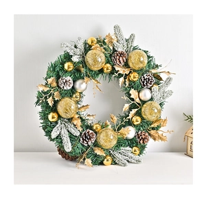 Detail of pine needle Christmas wreath with golden balls, pine cones and snow-covered tips
