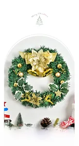 Detail of Christmas wreath with golden bells, reindeer, and pine needles on a white wall