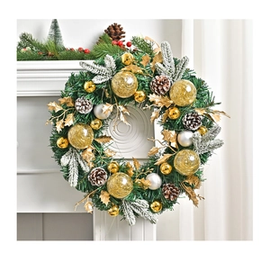 Detailed view of pine needles and frosted pine cones on a lit Christmas wreath decoration