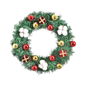 Handgefertigter Weihnachtskranz mit rot-goldenen Kugeln und Baumwolle auf weißem Grund