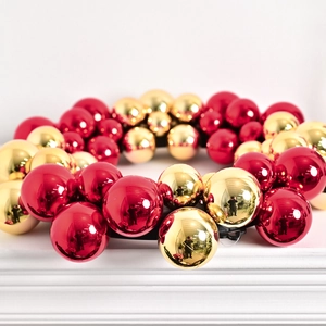 Festive Christmas wreath with shiny red and gold baubles on a white background