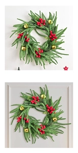 Macro detail of Norfolk fir wreath with red berry clusters and golden holiday bells