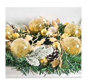 Macro detail of Christmas wreath with golden balls, pine needles, and snow-tipped pine cones