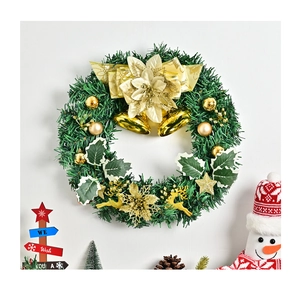 Detail of Christmas wreath with golden bells, fabric flowers, and reindeer on pine branches