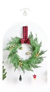 Detail of Christmas wreath with gold berries, bells, and red-black checkered bow knot