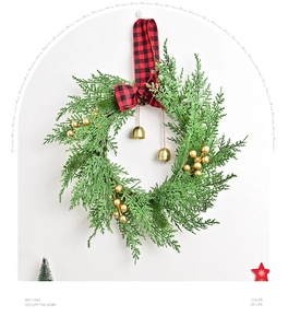 Close-up of Christmas wreath with golden bells, red plaid bow, and faux pine greenery