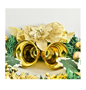 Close-up of golden metal bells and sparkling fabric flower on Christmas pine wreath