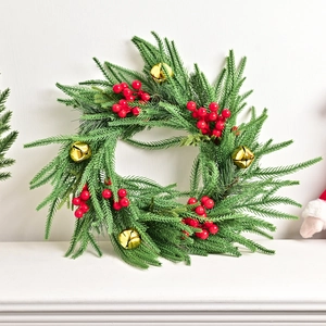 Norfolk pine Christmas wreath with red berries and golden bells for porch decor