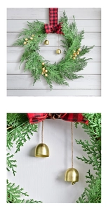 Detail of Christmas wreath featuring red plaid bow, golden bells, and pine cones decoration