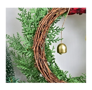 Close-up of Nordic Christmas wreath featuring gold bells, cypress leaves and linen rope