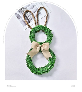 Close-up of Easter rabbit wreath with green leaves, vine ears and a burlap bow tie