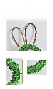Detail of bunny-shaped rattan wreath with lush green leaves for Easter home decoration
