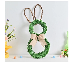 Detail of bunny wreath with green leaves, rattan ears and burlap bow for Easter decor