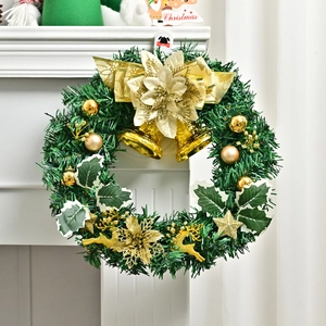 Christmas wreath with golden flowers, bells and pine needles on a white fireplace mantel