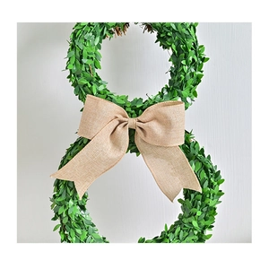 Detail of bunny-shaped boxwood wreath with large burlap bow for Easter home decor