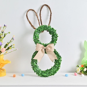 Easter bunny wreath with green leaves, rattan ears and a beige linen bow for home decor