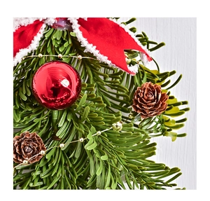 Detail of Christmas ornament featuring pine cones, red berries, and a festive red bow