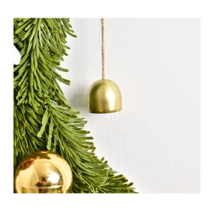 Detail of pine needles, golden bell and ornament on moon-shaped Christmas hanger