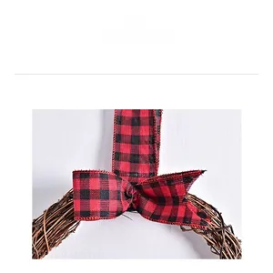 Close-up of rustic branch wreath with red and black buffalo plaid ribbon bow