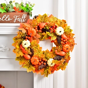 Autumn wreath with pumpkins, maple leaves and pine cones on a white fireplace mantel