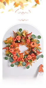 Detail of autumn wreath with faux pumpkins, pine cones, and orange maple leaves