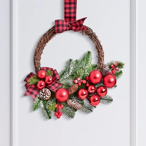 Christmas wreath with pine cones red ornaments and buffalo plaid bow on white door
