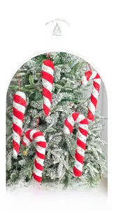 Detail of plush red and white candy cane ornament with gold snowflakes on Christmas tree