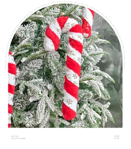 Close-up of red and white plush candy cane ornament with gold snowflake on Christmas tree