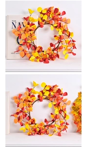 Close-up of autumn harvest wreath featuring maple leaves and pumpkin berry accents