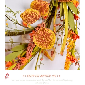 Close-up of autumn wreath featuring detailed yellow silk leaves and orange berries