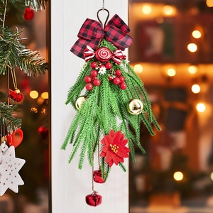 Couronne de Noël avec nœuds rouges, cloches et branches de sapin pour déco de porte