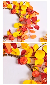 Detailed view of artificial orange pumpkins and gradient autumn leaves on a festive wreath