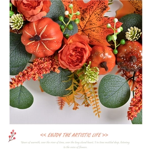Detail of autumn wreath with pumpkins, orange roses, maple leaves and eucalyptus leaves