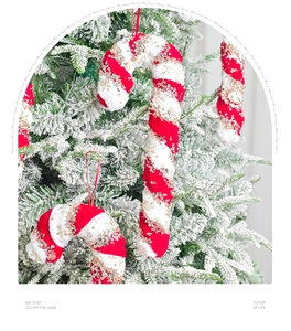 Close-up of red and white plush candy cane with gold sequins on a snowy Christmas tree
