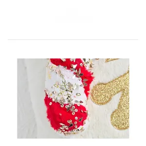 Detail of red and white plush Christmas cane ornament with festive gold sequin patterns