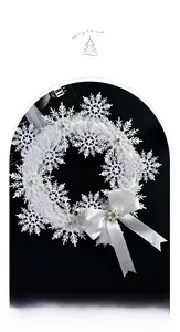 Dettaglio ghirlanda natalizia con fiocchi di neve bianchi, fiocco di raso e perla