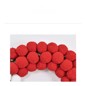 Detailed macro view of soft red and white plush pom-pom texture on a Christmas wreath