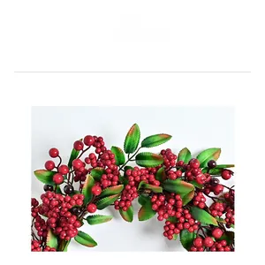 Detailed close-up of festive red berries and green serrated leaves on a Christmas wreath
